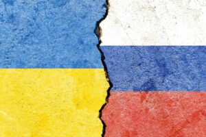 View of Ukraine vs Russia flags on cracked concrete wall – political partnership conflicts concept